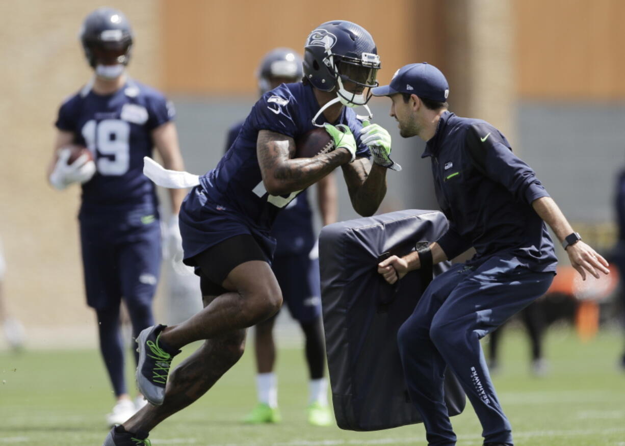 Seattle Seahawks wide receiver Brandon Marshall, center, runs a drill during NFL football practice, Wednesday, May 30, 2018, in Renton, Wash. (AP Photo/Ted S.