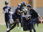 Seattle Seahawks wide receiver Brandon Marshall, center, runs a drill during NFL football practice, Wednesday, May 30, 2018, in Renton, Wash. (AP Photo/Ted S.