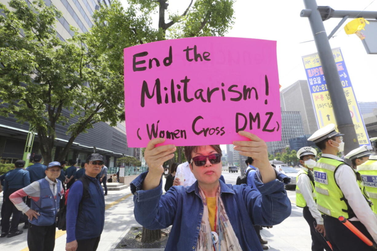 A protester holds a sign to wish for a peace on the Korea peninsular near U.S. Embassy in Seoul, South Korea, on Tuesday. The two Koreas will hold a high-level meeting on Wednesday to discuss setting up military and Red Cross talks aimed at reducing border tension and restarting reunions between families separated by the Korean War.