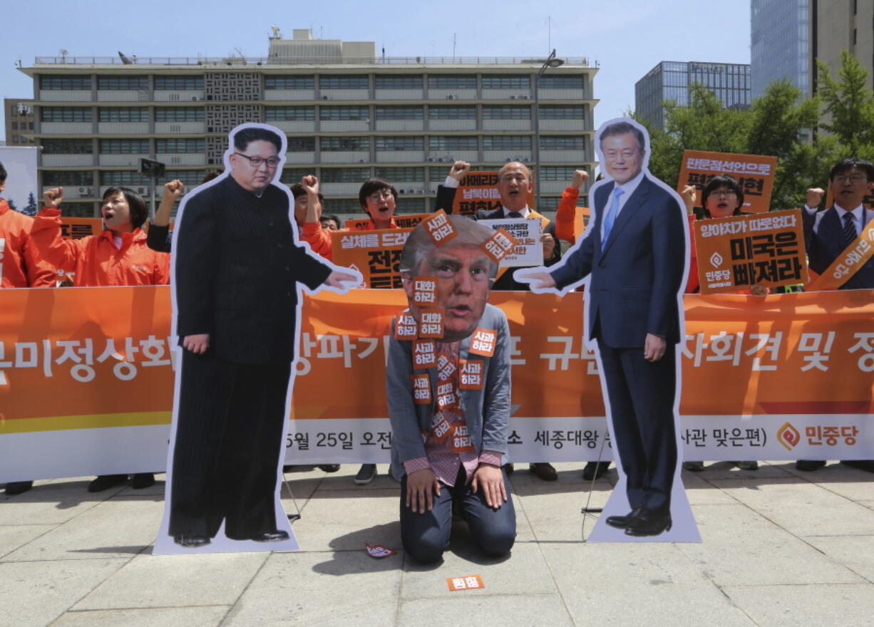 A protester wearing a mask of U.S. President Donald Trump, center, performs with cut-out photos of North Korean leader Kim Jong Un and South Korean President Moon Jae-in, right, during a rally against the United States’ policies against North Korea near the U.S. embassy in Seoul, South Korea, on Friday. North Korea said Friday that it’s still willing to sit down for talks with the United States “at any time, at any format” just hours after President Donald Trump abruptly canceled his planned summit with the North’s leader Kim Jong Un.