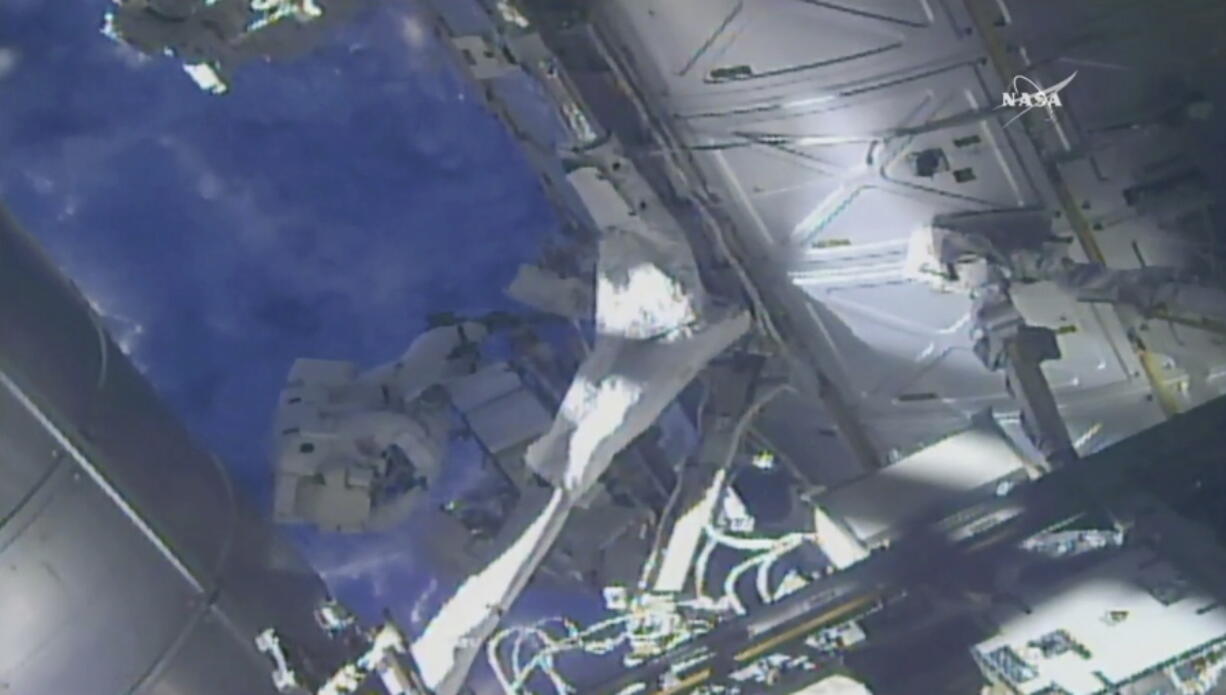 In this frame from NASA TV, NASA astronaut Ricky Arnold, left, and NASA astronaut Drew Feustel work on shuffling around a couple of space station pumps at the International Space Station on Wednesday.