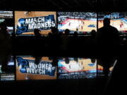 In this March 15, 2018 photo, people watch coverage of the first round of the NCAA college basketball tournament at the Westgate Superbook sports book in Las Vegas.