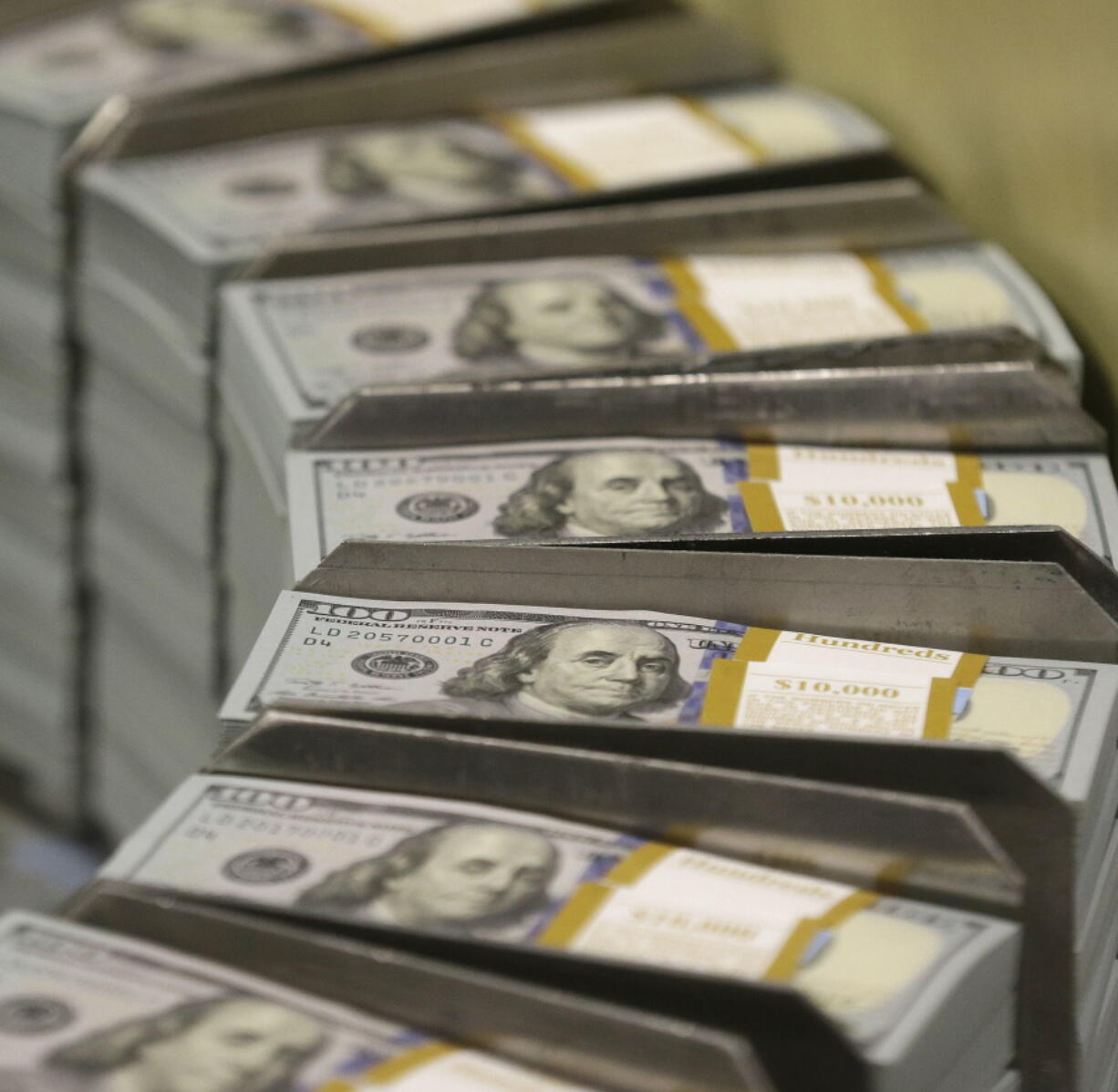 FILE - In this Sept. 24, 2013, file photo, just cut stacks of $100 bills make their way down the line at the Bureau of Engraving and Printing Western Currency Facility in Fort Worth, Texas. Everyone knows the tech industry is big, but it can be challenging to get your head around just how big it is. At least until you look at it from a different angle and realize that Apple makes more money in a day than 2500 average U.S. households can expect to see in a year.