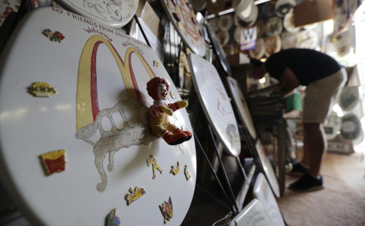 A visitor looks as some of the more than 1,350 decorated commode lids at Barney Smith’s Toilet Seat Museum in Alamo Heights, Texas. Smith, called “King of the Commode,” opened his commode museum in 1992 and is looking for a buyer who will preserve his collection intact.