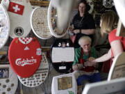 Retired plumber Barney Smith, 96, center, greets a visitor to his Toilet Seat Art Museum in Alamo Heights, Texas, on May 16.