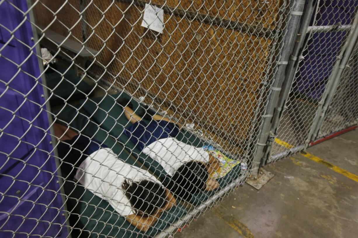 Two female detainees sleep in a holding cell, as the children are separated by age group and gender, as hundreds of mostly Central American immigrant children are being processed and held at the U.S. Customs and Border Protection Nogales Placement Center in Nogales, Ariz., on June 18, 2014. President Donald Trump has seized on an error by liberal activists for tweeting photos of detainees at the U.S.-Mexico border in steel cages and blamed the current administration for separating immigrant children from their parents. The photos were taken by The Associated Press in 2014, when President Barack Obama was in office. (Ross D.