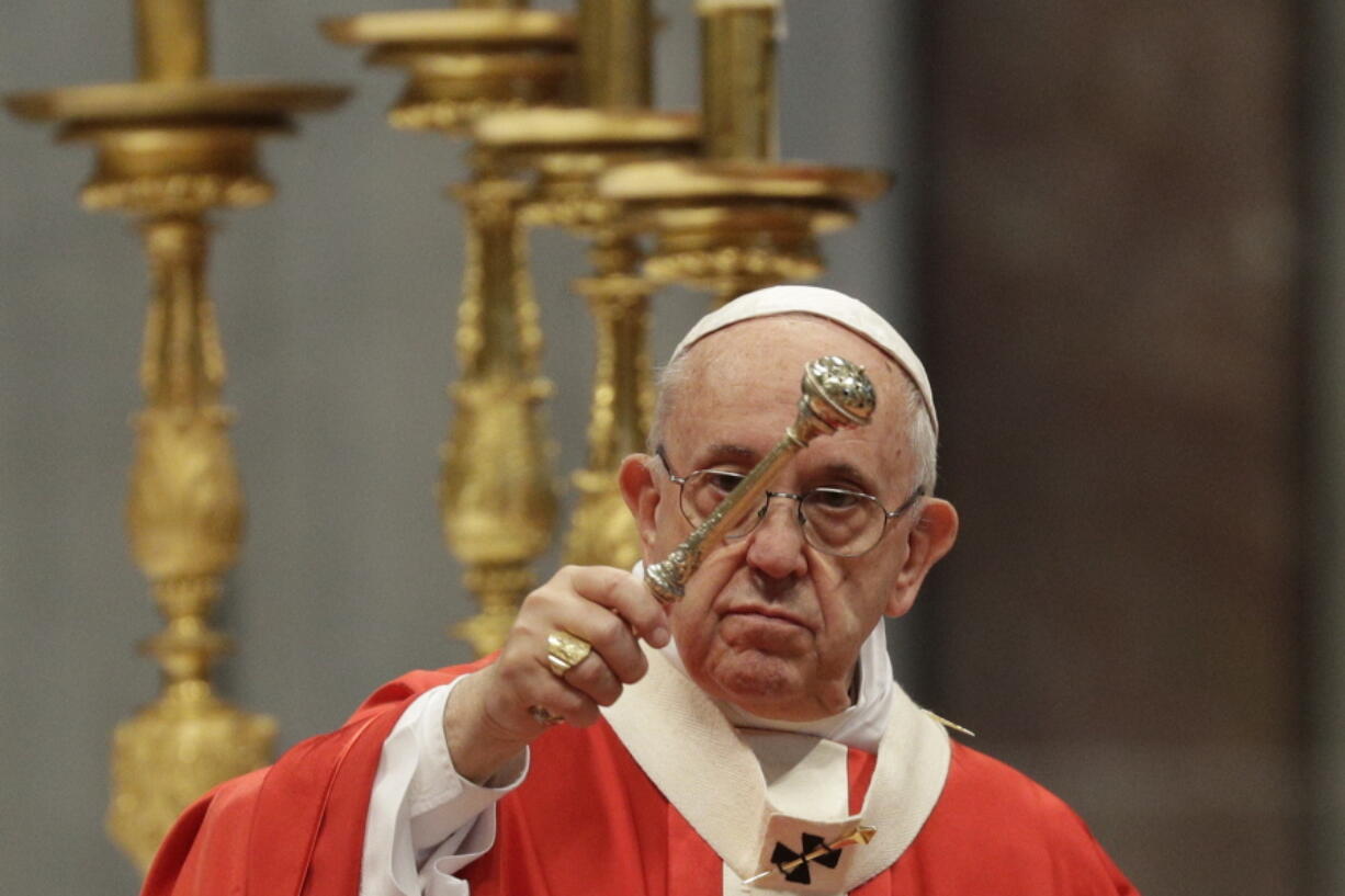 Pope Francis asperges holy water as he celebrates a Pentecost mass in St. Peter’s Basilica at the Vatican on Sunday.