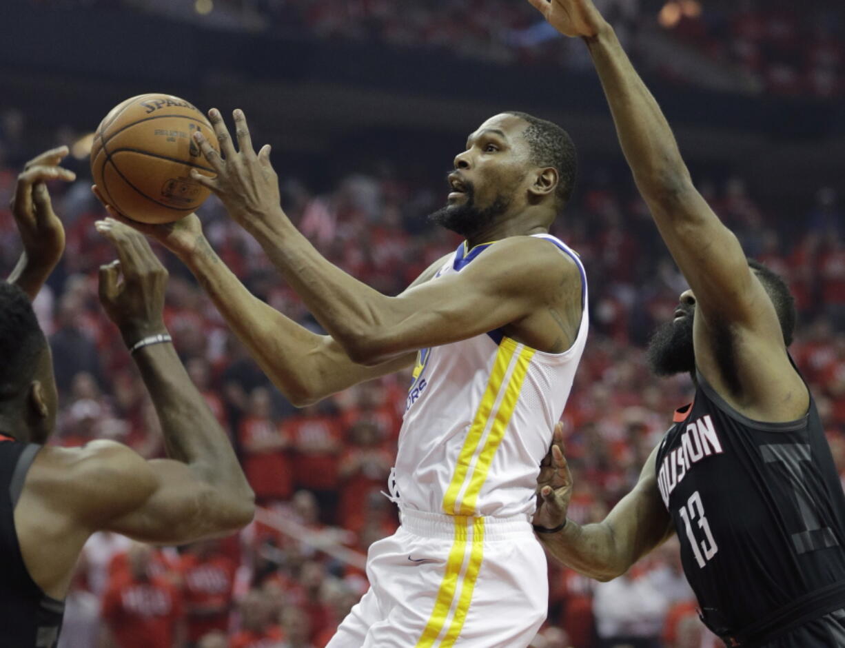 Golden State Warriors forward Kevin Durant (35) drives to the basket past Houston Rockets guard James Harden (13) during the first half of Game 1 of the NBA basketball Western Conference Finals, Monday, May 14, 2018, in Houston. (AP Photo/David J.