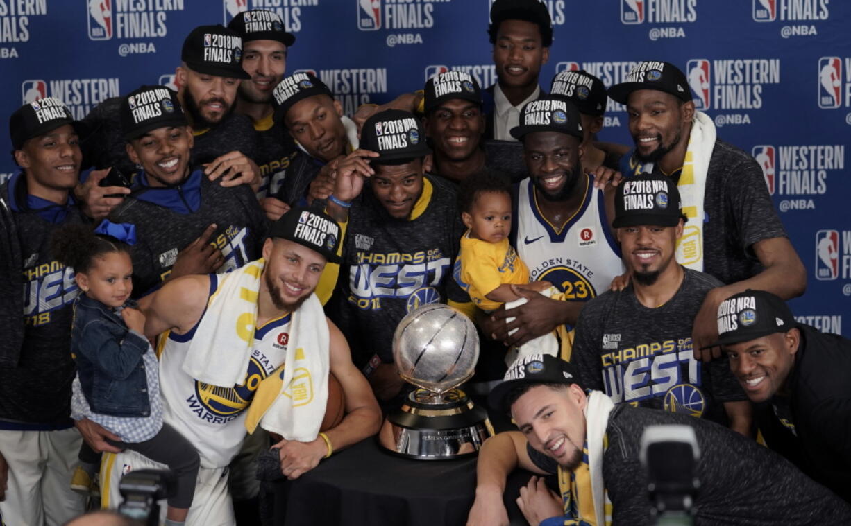 The Golden State Warriors pose with their trophy after defeating the Houston Rockets in Game 7 of the NBA basketball Western Conference finals, Monday, May 28, 2018, in Houston. (AP Photo/David J.