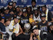 The Golden State Warriors pose with their trophy after defeating the Houston Rockets in Game 7 of the NBA basketball Western Conference finals, Monday, May 28, 2018, in Houston. (AP Photo/David J.