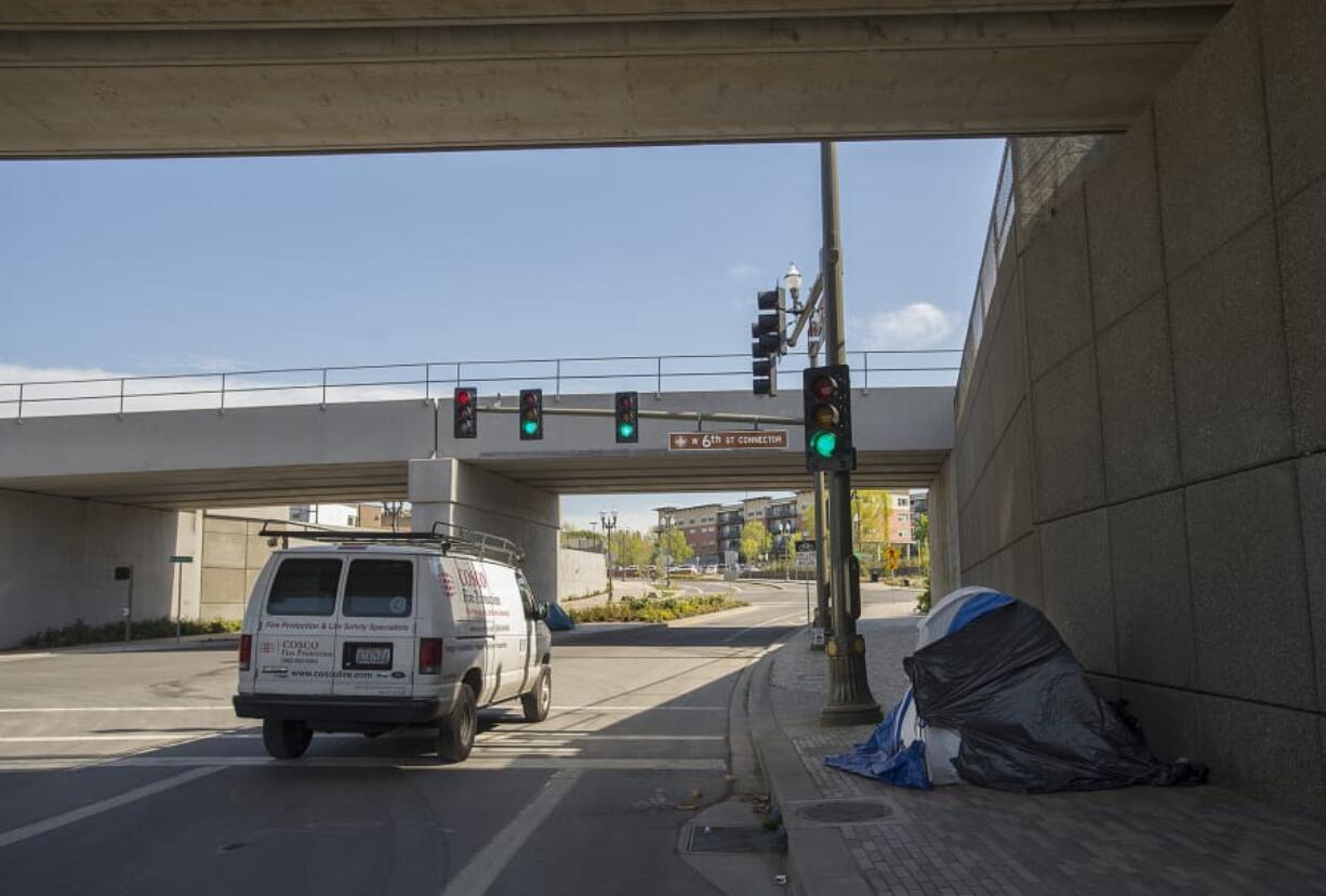 A motorist passes the tent of a homeless resident along an overpass on Grant Street in Vancouver in April.