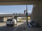 A motorist passes the tent of a homeless resident along an overpass on Grant Street in Vancouver in April.