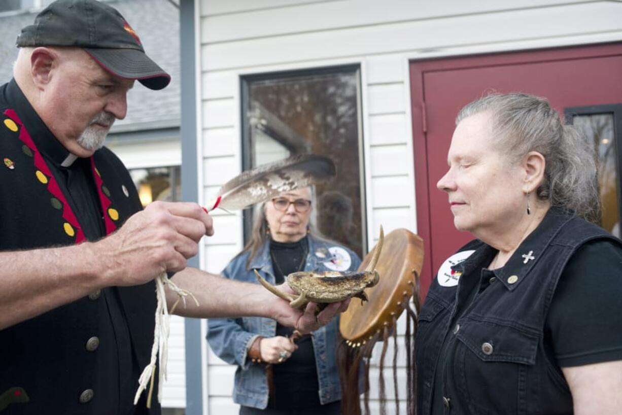 The Rev. Joe Scheeler performs a smudging on Traveling Day Society member Cheryl-Lee Holt before the Good Friday service at All Saints Episcopal Church. The church borrows ceremonies from indigenous people to enhance their worship.