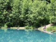 The “Lower Twin Lake” is a deep sinkhole created by groundwater erosion within the center of the Collins Landslide in the Columbia River Gorge. The lake’s groundwater carries a powder-blue cast. The prehistoric landslide dates to the Missoula floods, but activity has slowed since the mid-1970s.