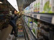 Vongxay Kikdavong of Vancouver, originally from Laos, stocks the shelves with mango juice and coconut water at Tola Angkor Asian Market in Vancouver in January.