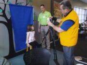 Orchards: Harper Martin, 4, has her picture taken by Jim Terrell as part of the Orchards Lions Club’s annual identification project, in which they create ID cards for kids.