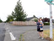 Heather Sinnott, chairwoman of the Burnt Bridge Creek Neighborhood Association, stands with her 2-year-old son, Henry, as she points to the intersection near her home on Northeast Poplar Street where the neighborhood association is hoping to paint a mural to slow down traffic. The speed limit where Poplar Street turns into Northeast 47th Street is 25 mph, but Sinnott says many drivers far exceed this speed and that it is dangerous for the neighborhood.