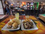 Barbecue pork sliders, clockwise from left, with a tequila punch cocktail, a green tea cocktail and a pastrami sandwich at the Offramp Sports Bar & Grill.