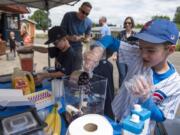 Gardner School second-graders Dashiell Weiss, right, and his Team Smoothie business partner Ben Wheeler, left, make smoothies during the annual Gardner Market on Friday. The event gives the students a chance to become entrepreneurs for a day and help raise money for nonprofits. This year the event will benefit the Eagle Creek Fire Restoration Fund and The Ocean Cleanup.