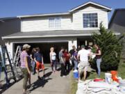 Volunteers with Michelle’s Love, a small nonprofit that helps single moms with cancer, did yard work, cleaned and painted the inside of Christy Castro’s house in Vancouver on Saturday.