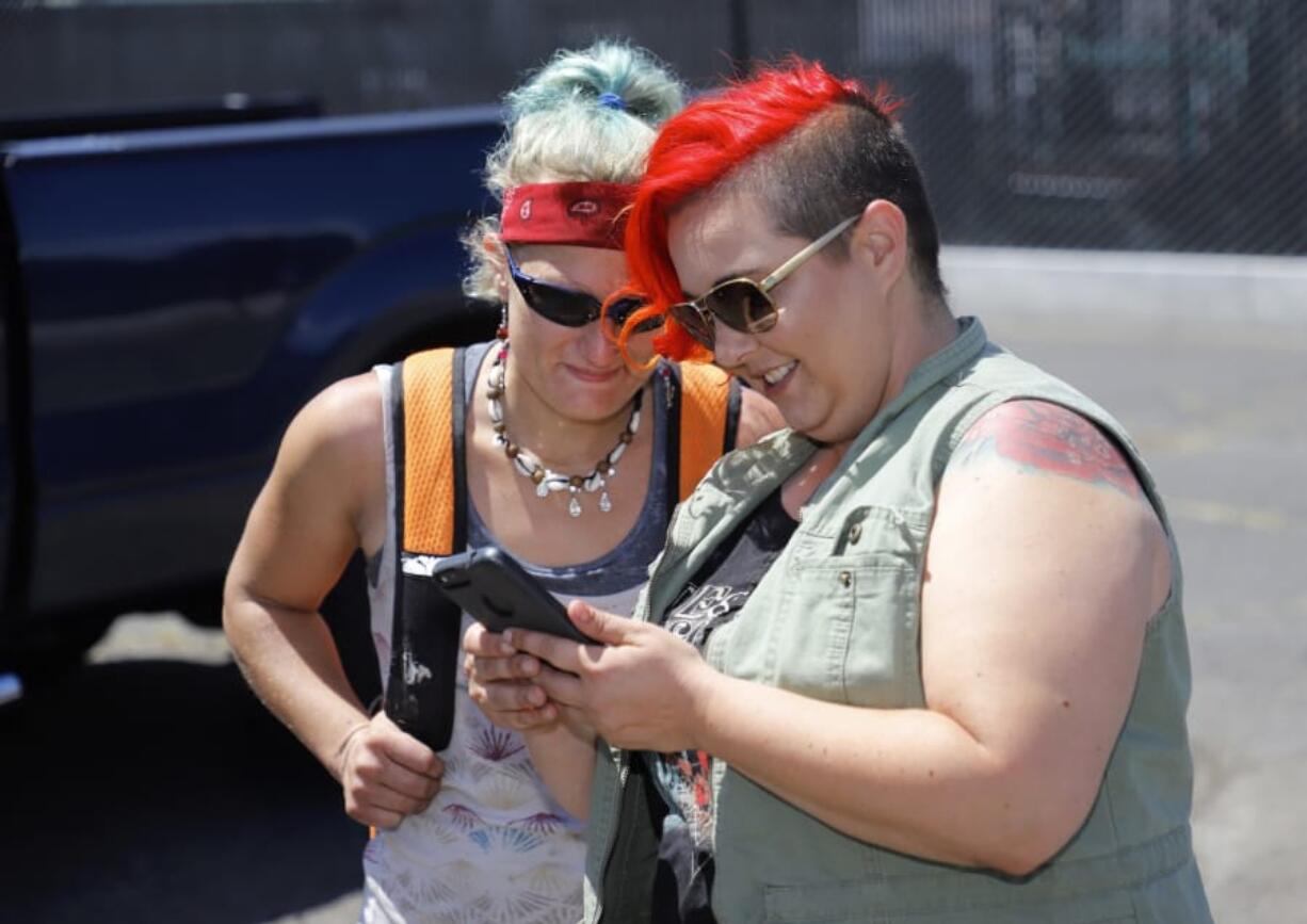 Jamie Spinelli, right, visits with Andriea Hayes at her mobile shower trailer parked outside of Friends of the Carpenter.