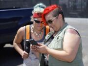 Jamie Spinelli, right, visits with Andriea Hayes at her mobile shower trailer parked outside of Friends of the Carpenter.