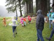 A race, led by organizer Michelle Fox, right, happened even in the Sunday rain at Fallen Leaf Lake Park in Camas. Fox founded TreeSong Nature Awareness to foster stewardship of and a connection to nature and the local community through programs for children, adults and families.