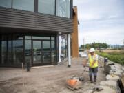 Efren Martinez Zavala with GRO Outdoor Living works on the outdoor patio outside The Black Pearl in Washougal. The long-unused building is expected to open as an events center in August.