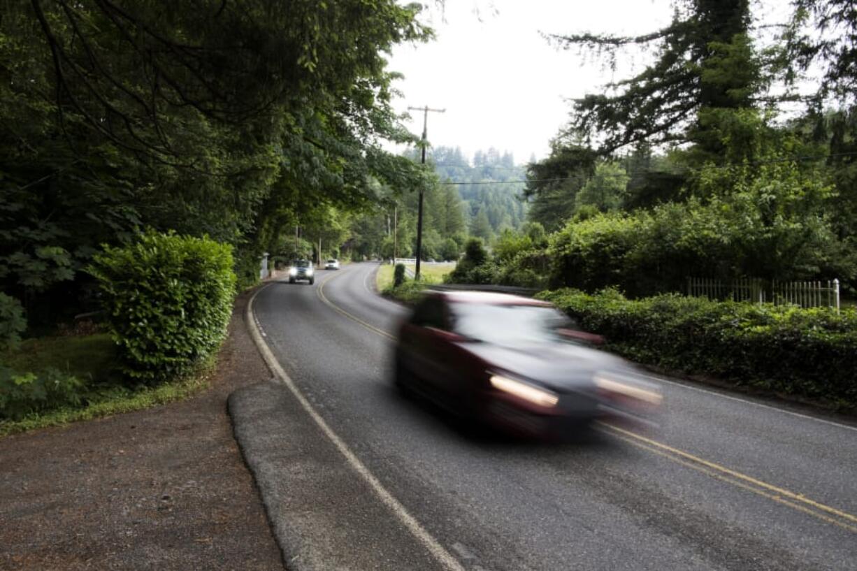 Cars drive along Northeast Washougal River Road, where some residents would like to see the speed lowered or some traffic-calming measures installed, as they say drivers go too fast on the curvy street.