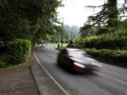 Cars drive along Northeast Washougal River Road, where some residents would like to see the speed lowered or some traffic-calming measures installed, as they say drivers go too fast on the curvy street.