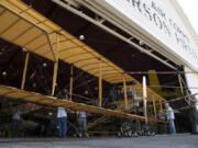 Plane builders and Fort Vancouver staff members ease the Curtiss Pusher into the Pearson Air Museum at Fort Vancouver National Historic Site on Tuesday.