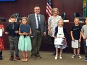 Battle Ground: Tukes Valley second-graders were honored by Battle Ground Mayor Mike Dalesandro, back row from left, and Battle Ground Art Alliance President Dotty Yackle-Kay for their artwork depicting Community Helpers, which was hanging in city hall. From left: Celia Cavens, Karson Win’E, Ella Antonov, Stella Potter, Lincoln Toland and Tim Didyk.