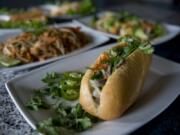 Banh mi with lemongrass beef, foreground, is served with other dishes at Pho Haven in Uptown Village on Friday afternoon, June 15, 2018.