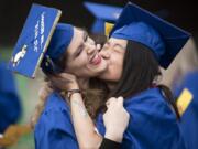 Lydia Straub, left, who is graduating with an Associate of Arts degree, tries to evade a kiss from Meizhi Teoh, graduating with an Associate of Arts with honors, before the 2018 Clark College Commencement Ceremony on Thursday evening at the Sunlight Supply Amphitheater.