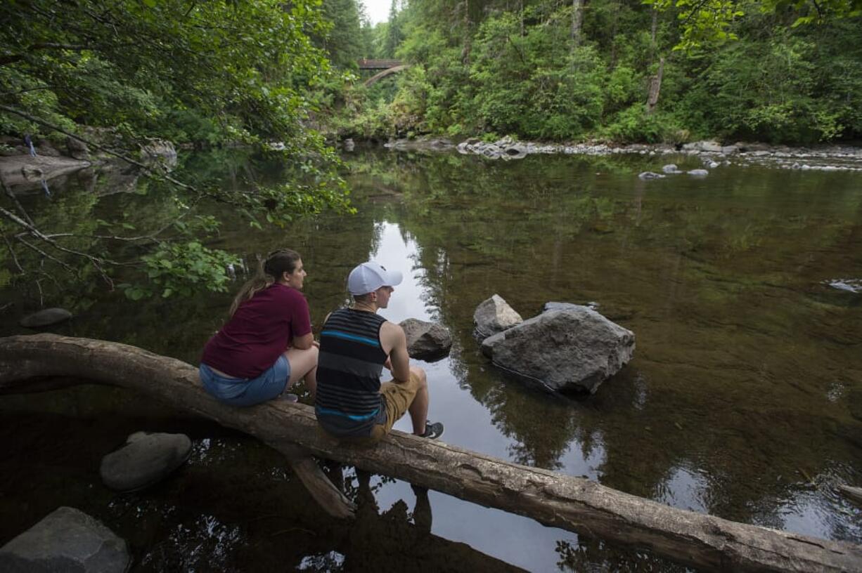 Noaa Boris, left, and Connor Guenther, both of Battle Ground, look out on the low water levels of the East Fork Lewis River just above Moulton Falls Park. A hot and dry spring melted much of the regional snowpack and has lowered runoff and precipitation of waterways.