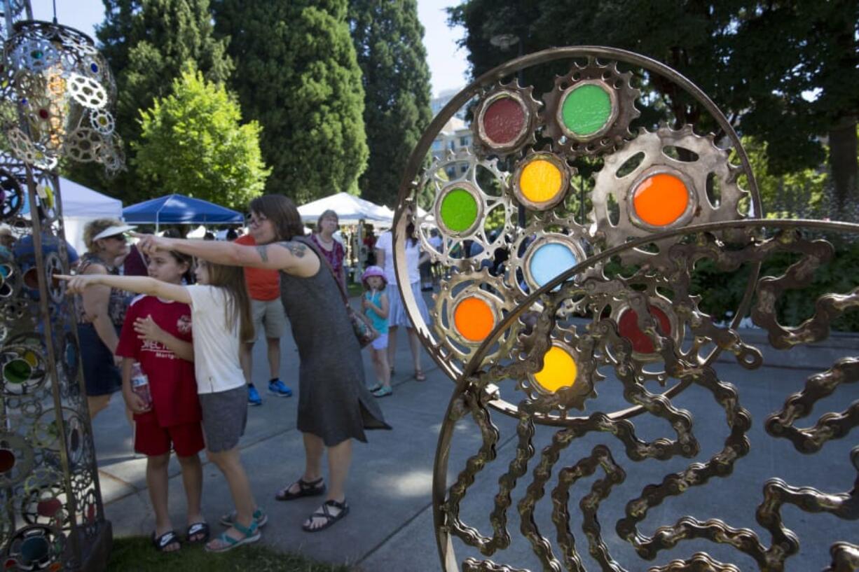 Visitors shop at the Recycled Arts Festival in Vancouver on Sunday. The art here was made by Brian Echerer from bicycle parts.