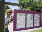 Camas artist Anna Norris look at a glass creation at the Recycled Arts Festival in Vancouver on Sunday. The piece was made by artist Darla Lynn.