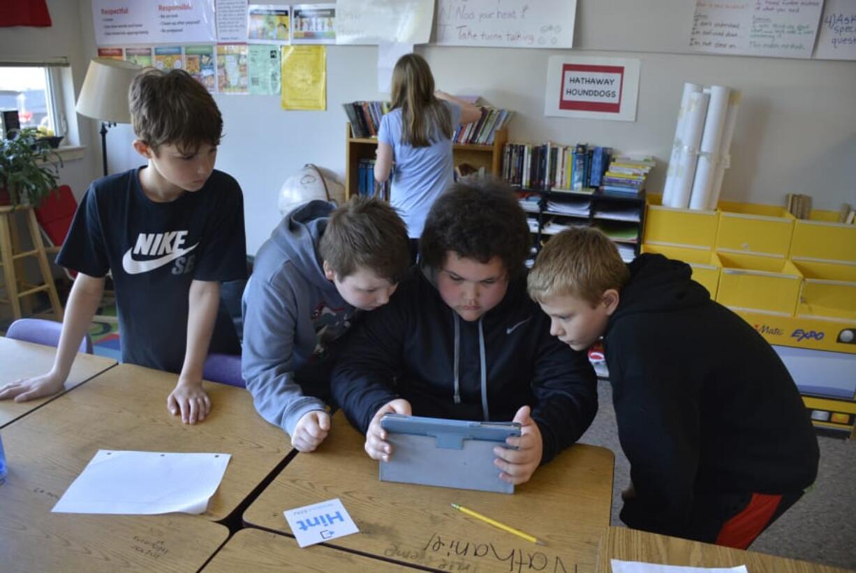 Washougal: Hathaway Elementary School fifth-graders, from left, Evan Elliott, Dylan Gray, Nathaniel Tauialo and Justin Ziegler work on a puzzle during an escape room-like lesson in class.