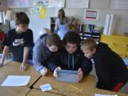 Washougal: Hathaway Elementary School fifth-graders, from left, Evan Elliott, Dylan Gray, Nathaniel Tauialo and Justin Ziegler work on a puzzle during an escape room-like lesson in class.