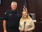 Clark County Fire District 3 Chief Scott Sorenson presents Emily Davidson with a plaque honoring her for helping provide first aid to an 82-year-old woman who collapsed at a seniors dance.