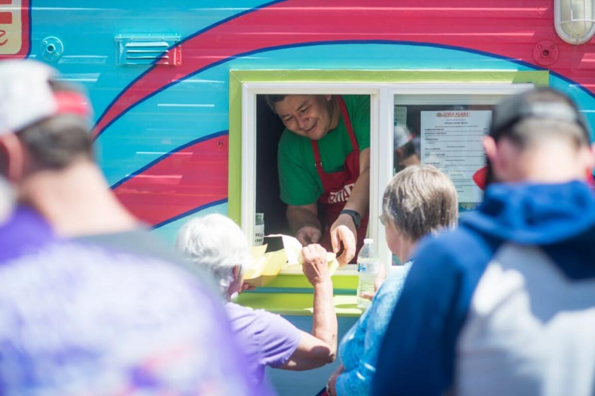 Tobias McKibben serves tamales from Vida Flare food cart at the inaugural Southwest Washington Tamale Festival in Washougal on Saturday. The festival was rescheduled after getting rained out last October. Top: Foody Blues was one of the vendors participating in the festival. They ran out of tamales halfway through the day.