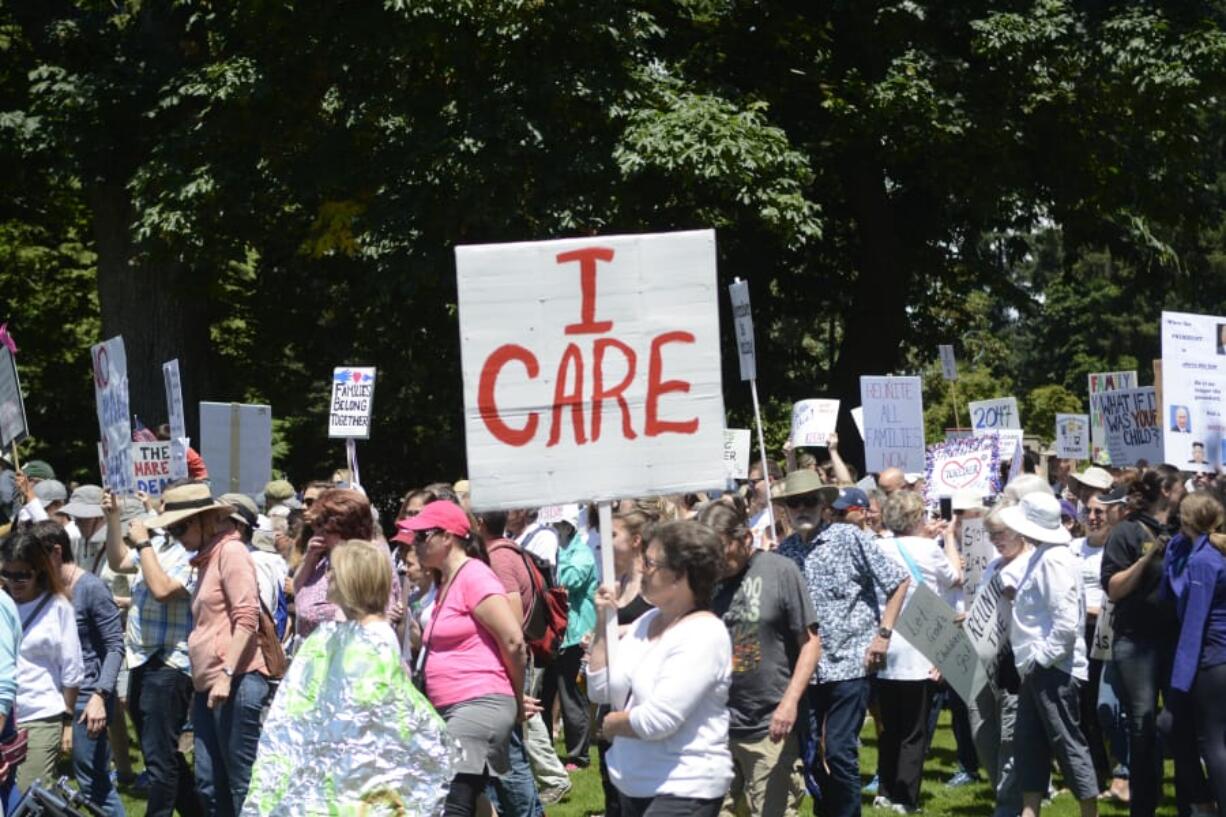 Protesters march Saturday from Rep. Jaime Herrera Beutler’s office to Esther Short Park in downtown Vancouver.