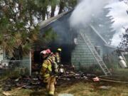 Firefighters work on a house fire near Battle Ground Monday.