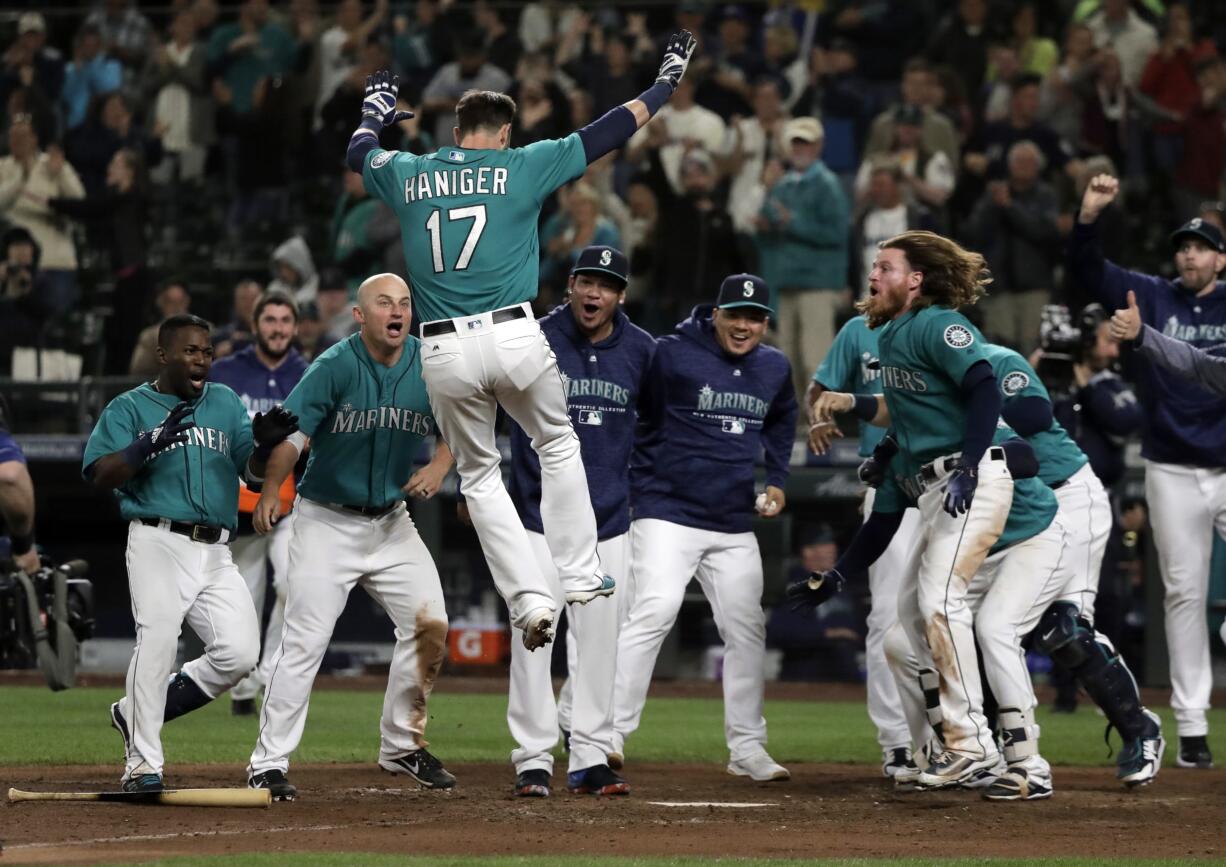 Seattle Mariners' Mitch Haniger (17) leaps onto home plate after he hit a walk-off home run against the Tampa Bay Rays during the 13th inning of a baseball game, Friday, June 1, 2018, in Seattle. The Mariners won 4-3 in 13 innings. (AP Photo/Ted S.