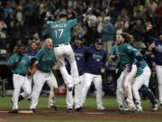 Seattle Mariners' Mitch Haniger (17) leaps onto home plate after he hit a walk-off home run against the Tampa Bay Rays during the 13th inning of a baseball game, Friday, June 1, 2018, in Seattle. The Mariners won 4-3 in 13 innings. (AP Photo/Ted S.