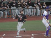 Oregon State's Nick Madrigal scores as LSU catcher Nick Coomes stands in front of the plate during an NCAA college baseball tournament regional game in Corvallis, Ore., Saturday, June 2, 2018.