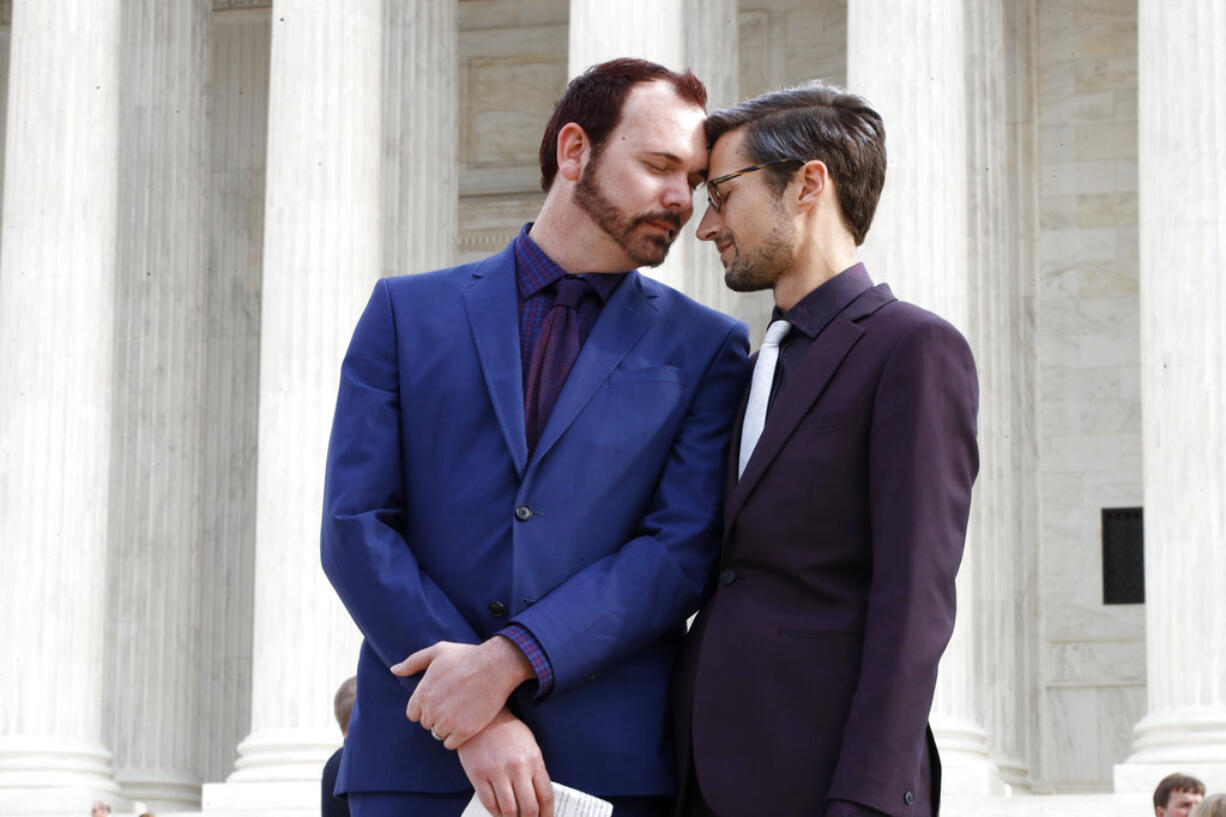 In this Dec. 5, 2017 file photo, Charlie Craig, left, and David Mullins touch foreheads after leaving the Supreme Court in Washington. The Supreme Court is setting aside a Colorado court ruling against a baker who wouldn’t make a wedding cake for a same-sex couple. But the court is not deciding the big issue in the case, whether a business can refuse to serve gay and lesbian people.