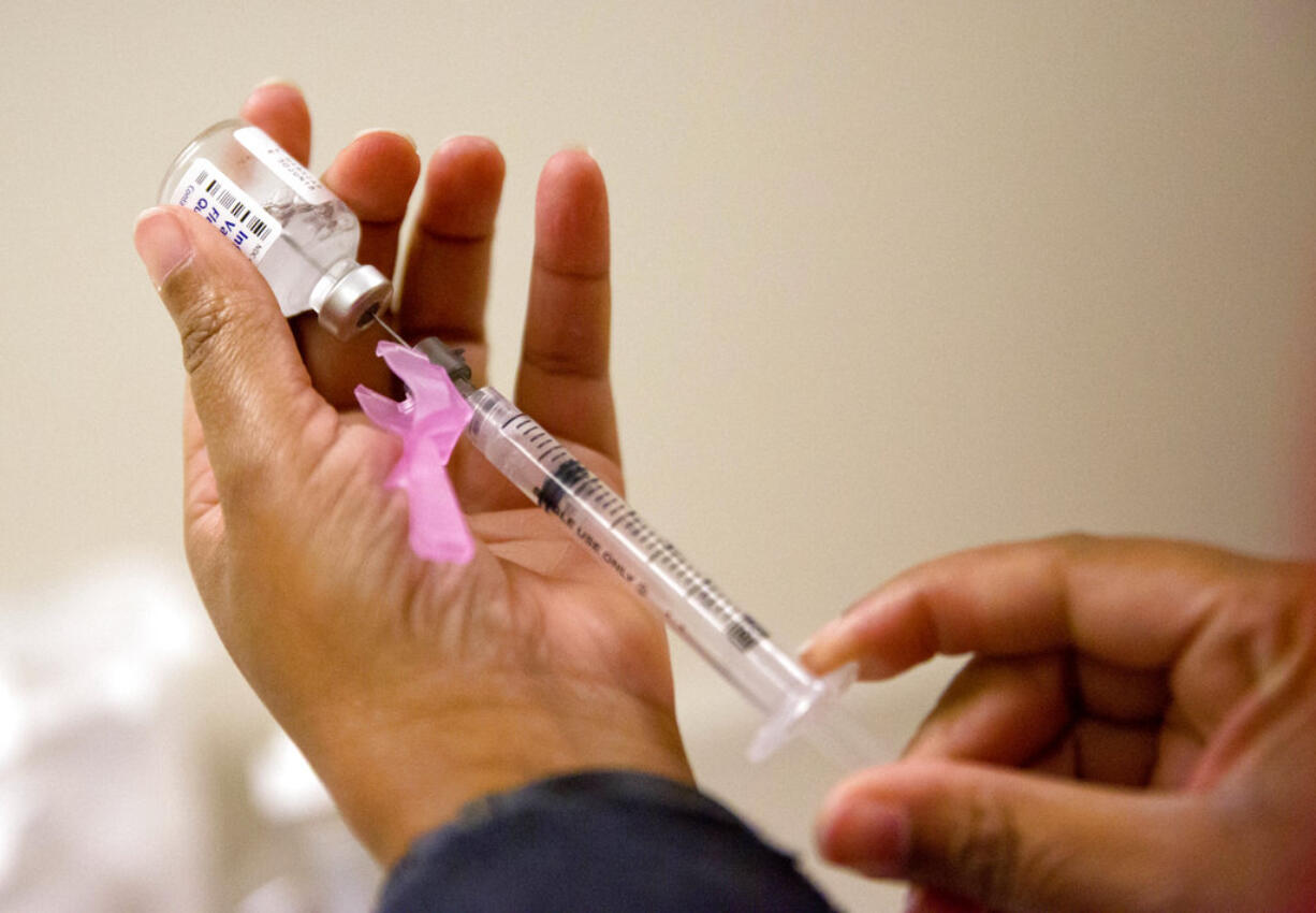 FILE - In this Wednesday, Feb. 7, 2018 file photo, a nurse prepares a flu shot in Atlanta. On Friday, June 8, 2018, health officials said the flu killed more children in the past year that during any other regular flu season in recent history.