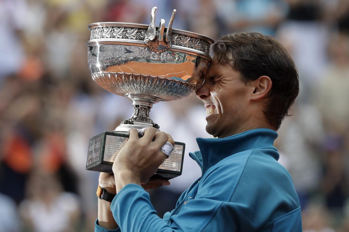 Spain's Rafael Nadal holds the trophy as he celebrates winning the men's final match of the French Open tennis tournament against Austria's Dominic Thiem in three sets 6-4, 6-3, 6-2, at the Roland Garros stadium in Paris, France, Sunday, June 10, 2018.