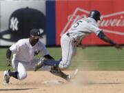 Seattle Mariners pinch runner Guillermo Heredia (5) is caught stealing as he is tagged out by New York Yankees shortstop Didi Gregorius (18) during the eighth inning of a baseball game Thursday, June 21, 2018, at Yankee Stadium in New York.